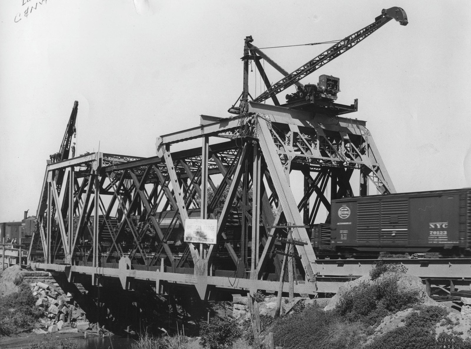 Construction photo of bridge, showing unique method of erecting truss around previous bridge